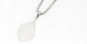 Macro view of frosted leaf pendant and stainless steel box chain detail