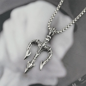 Collier trident gothique en argent vintage sur fond de page de magazine