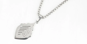 Detail of matte leaf pendant with box chain showing the texture and square engraving