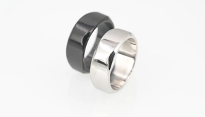 Macro shot of minimalist black and silver polished titanium steel rings for couples