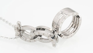Macro detail of silver titanium steel necklace pendant engraved with Forever text