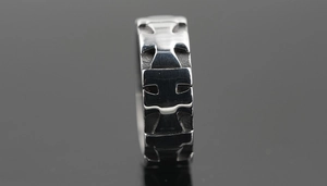 Macro shot of silver vintage gothic ring featuring continuous cross relief engraving