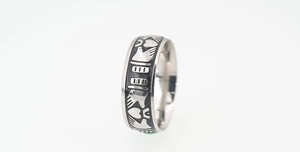 Close-up of Claddagh ring with black enamel details and crown design on stainless steel