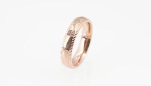Vue détaillée d'une bague en or rose avec gravure couronne et petit diamant serti