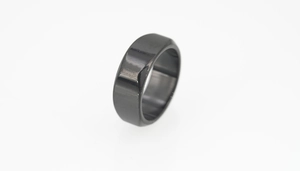 Macro detail of polished black titanium ring showing beveled edges and glossy finish