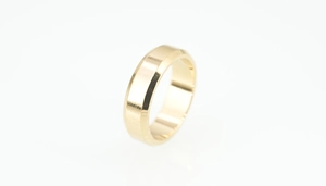 Macro detail of beveled gold stainless steel ring featuring a polished finish and sleek edges