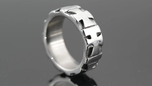 Macro close-up of a silver titanium steel ring featuring hollow cross patterns and gothic style