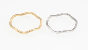 Detailansicht unregelmäßiger Wellenringe in Gold und Silber mit glatter Metalloberfläche