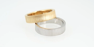 Detail of minimalist brushed metal rings in gold and silver with polished inner band surface