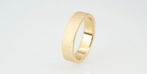 Detail view of gold matte brushed surface and polished inner band titanium steel ring