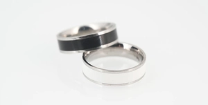 Macro shot of black and white ceramic steel rings with polished silver edges
