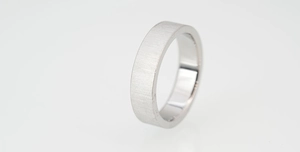 Macro detail of silver titanium ring with brushed texture exterior and polished interior