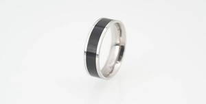 Macro shot of wide titanium steel ring with polished silver finish and black center band