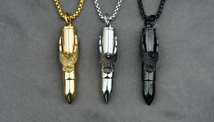 Vue détaillée des pendentifs balle avec motif aigle en finitions or, argent et noir mat