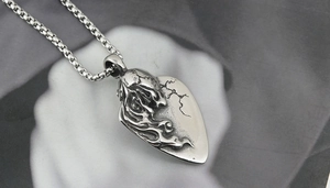Close-up of heart-shaped skull pendant in retro gothic style on a steel chain