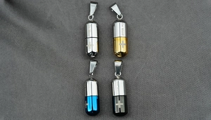 Détail de pendentifs capsules polis en titane disponibles en argent, or, bleu et noir