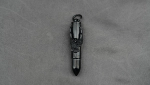 Vue macro d'un pendentif balle en acier titane noir avec gravure d'aigle détaillée