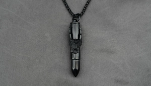 Détail du pendentif balle avec aigle noir sculpté et chaîne à perles carrées assortie
