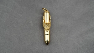 Vue détaillée du pendentif balle dorée avec une décoration d'aigle finement gravée