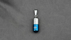 Vue détaillée du pendentif capsule en acier titane bicolore avec motif de croix