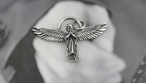 Close-up of retro titanium steel angel wing pendant in a praying hands posture