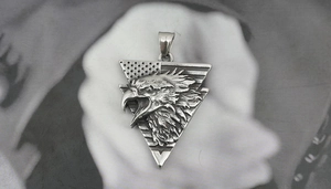 Detailed view of embossed eagle pendant with stars and stripes in vintage steel finish