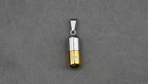 Détail du pendentif en acier inoxydable en forme de capsule avec croix et gravure