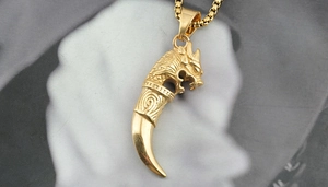 Close-up of golden dragon head pendant with tusk on box chain necklace