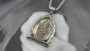 Macro shot of Ganesha pendant featuring a two-tone metal relief on a durable steel chain