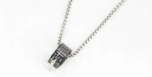 Close-up of titanium steel necklace featuring cross ring pendant with Spanish prayer