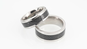 Gros plan de bagues en titane pour hommes avec insert en fibre de carbone noire sur argent