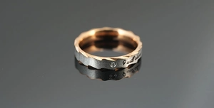 Makroansicht: Gebürsteter Stahlring in Silber und Roségold mit Diamant und I will always Gravur