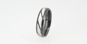 Detail view showing black polished finish and silver brushed texture on titanium ring