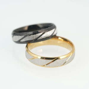 Minimalist black and gold stainless steel couple rings with brushed diagonal stripes