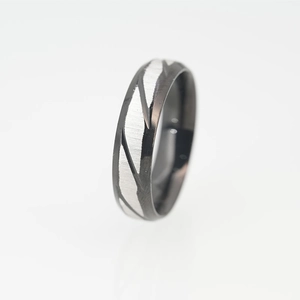Modern black and silver stainless steel ring with geometric brushed metal texture