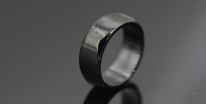 Macro view of men's titanium steel ring featuring matte and polished black finish