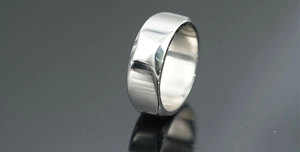 Close-up of polished silver titanium steel ring with wide band and mirror finish