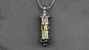 Macro detail of Buddhist cylinder pendant with gold Lotus petals and mantra engravings