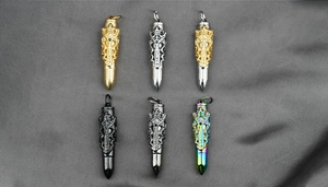 Macro detail of bullet-shaped cremation pendants with gothic cross designs in various colors