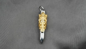 Detailed macro view of dual-tone dragon-patterned bullet pendant with crystal inlay