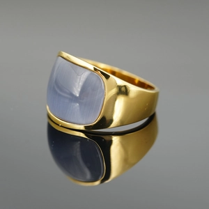 Goldener Siegelring mit ovalem blauem Katzenaugenstein auf dunkler Spiegelfläche