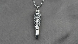 Macro shot of a bullet pendant with gothic hollow carving and silver box chain