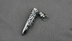 Macro shot of stainless steel bullet pendant with dragon relief and screw cap closure