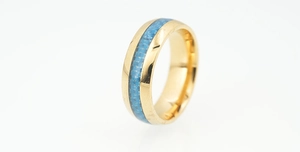 Detailed close-up of golden stainless steel ring with blue mosaic carbon fiber inlay
