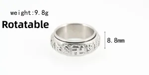 Close-up of rotatable silver titanium steel ring with engraved Buddhist mantras