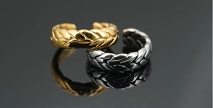 Macro detail of vintage wheat pattern rings in gold and silver finish on mirror