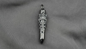 Detail of gothic silver bullet pendant featuring vintage totem and skull engravings