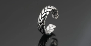 Macro shot of retro silver adjustable ring with intricate woven wheat pattern texture