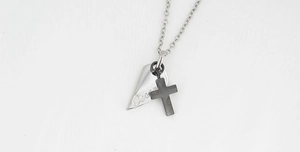 Detailed macro view of titanium steel cross pendant with silver Forever engraved tag