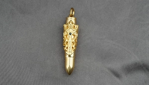 Detail view of golden bullet pendant with gothic cross relief and black stone inlay